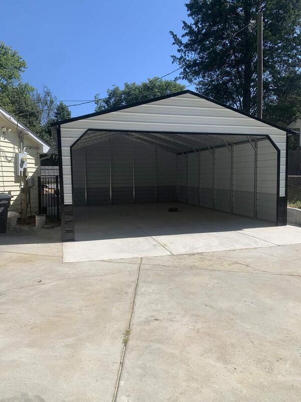 White metal carport with black trim, enclosed sides and back, and an open front on a concrete driveway